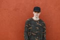 Nice handsome young man in a stylish black cap in a trendy green military shirt in jeans posing in the city Royalty Free Stock Photo