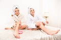 Nice happy young women smearing cream on their legs Royalty Free Stock Photo