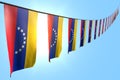 Nice holiday flag 3d illustration - many Venezuela flags or banners hanging diagonal on string on blue sky background with soft