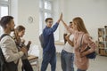 Team of happy university students celebrating their success and high fiving each other Royalty Free Stock Photo