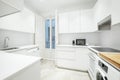 Nice kitchen of a short-term rental apartment with white furniture