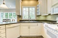 Nice kitchen with white cabinets and black countertops.