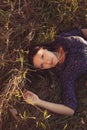 Nice lady dark-haired lying in autumnal grass top view