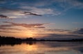 Nice landscape with sunset on lake. View of sky reflection on water and birds flying in the sky. Royalty Free Stock Photo