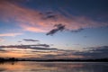 Nice landscape with sunset on lake. View of sky reflection on water and birds flying in the sky. Royalty Free Stock Photo