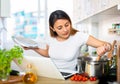 Nice latino woman planning to cook, looking for recipe on internet Royalty Free Stock Photo