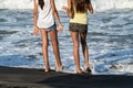 Nice legs of a pretty girl in jeans shorts standing in water. Close-up view of girls`s legs on the beach