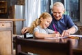 Nice little girl drawing with her grandfather