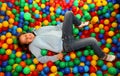 Nice little girl playing in the pool with colored plastic balls Royalty Free Stock Photo