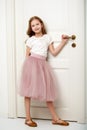 A little girl is standing by the door. Royalty Free Stock Photo