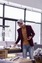 Nice-looking fancy male designer checking papers at office desk