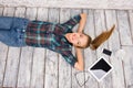 Nice-looking girl with tablet, spectacles, phone and cup lying on the floar Royalty Free Stock Photo