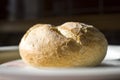 A photo showing a tasty roll on a plate on a sunny day.