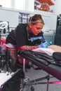 nice-looking young tattooist girl working in her tattoo salon, tattoo artist concept