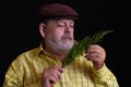 Portrait of a thoughtful Caucasian bearded senior admiring small branch of juniper tree Royalty Free Stock Photo