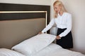 Nice maid prepares a bed for guests