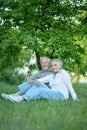 Nice mature couple sitting on green grass Royalty Free Stock Photo