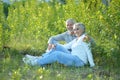 Nice mature couple sitting on green grass Royalty Free Stock Photo