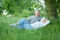 Nice mature couple sitting on green grass Royalty Free Stock Photo