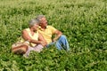 Nice mature couple sitting on green grass in summer park Royalty Free Stock Photo