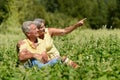 Nice mature couple sitting on green grass in summer park Royalty Free Stock Photo