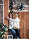 Nice man and woman 35 years old with white sweaters and jeans on the background of a beautiful Christmas decorated house Royalty Free Stock Photo