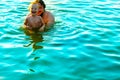 The little boy in his father's arms, in the waves of the sea. Dad with the little child on vacation. Royalty Free Stock Photo