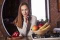 Nice mood. Pretty young woman standing in the modern kitchen near gas stove