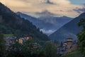 Nice mountain village located in the valley next to the green forest under a cloudy sky Royalty Free Stock Photo