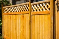 Nice new wooden fence around house. Wooden fence with toppers. Red wood fence with lattice panels Royalty Free Stock Photo