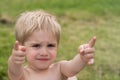 Nice offended kid with insulted expression face, points with forefingers (concept of children\'s emotions)