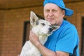 Outdoor portrait of two happy friends - mature man and his lovely young dog Royalty Free Stock Photo