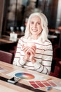 Pleasant senior woman holding a cup of tea and smiling Royalty Free Stock Photo