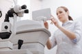 Nice pleasant woman working with eye testing equipment Royalty Free Stock Photo