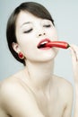 Nice pretty woman biting a chili pepper Royalty Free Stock Photo