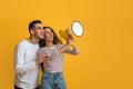 Nice Promo. Cheerful Arab Couple Using Megaphone For Making Announcement Royalty Free Stock Photo