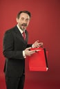 Nice purchase. Shocking discount. Mature businessman hold paper bag gift red background. Shopping concept. Christmas