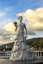 Sculpture of bride girl in dress with bouquet of bride flowers