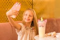 Nice selfie. little girl spend free time in cafe. Natural beauty. Childhood happiness. make selfie on unicorn phone Royalty Free Stock Photo