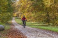 Senior woman on e mountain bike in autumn forest