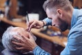 Nice serious barber shaving his client Royalty Free Stock Photo