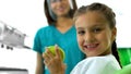 Nice teenage girl holding green apple and smiling at camera, children teeth care