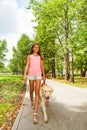 Nice teenage girl walk her dog in park alley Royalty Free Stock Photo