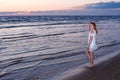 Nice teenager girl is walking near the sea at the seashore at th