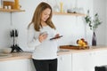 So nice to hear you Beautiful young pregnant woman talking on phone and looking away with smile while standing at kitchen interior Royalty Free Stock Photo