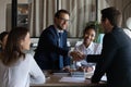 Friendly young man leader shake hand of new staff member