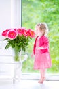 Nice toddler girl playing with peony flowers Royalty Free Stock Photo