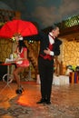 Nice trick - an impressive magician and his beautiful brunette assistant, bright stunt on stage.