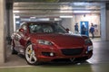 maroon red Mazda RX8 in the dark garage