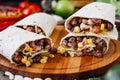 Nice vegetarian burrito over black table on wooden board. Royalty Free Stock Photo